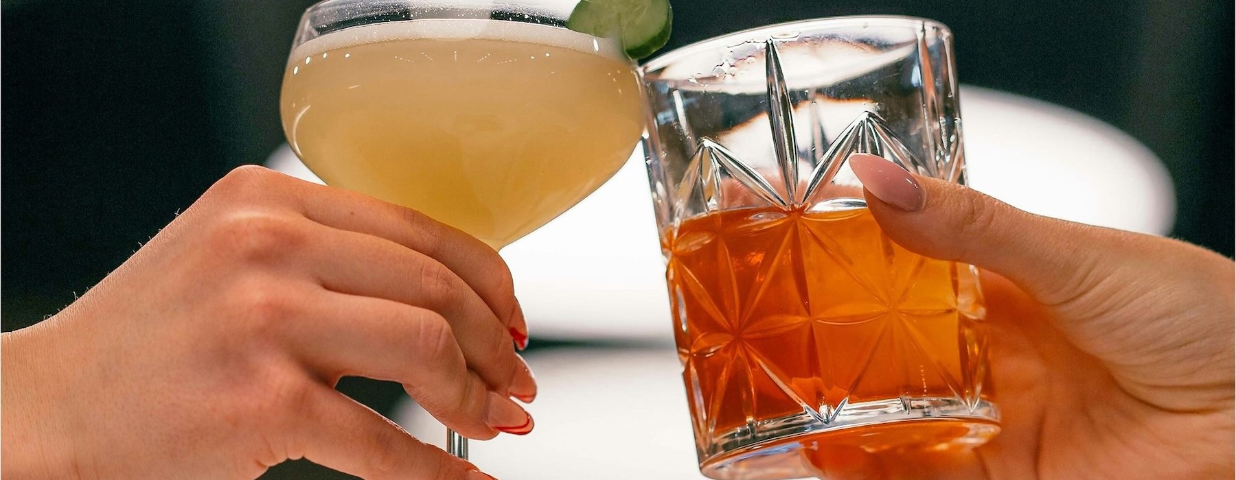 hands holding glasses with cocktails