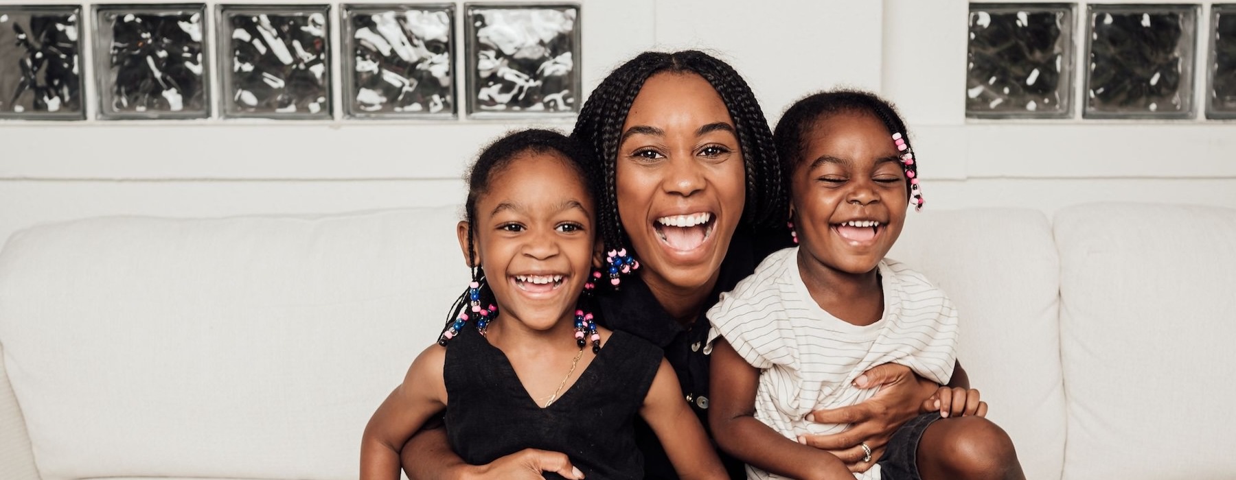 a woman sitting on a couch with two kids
